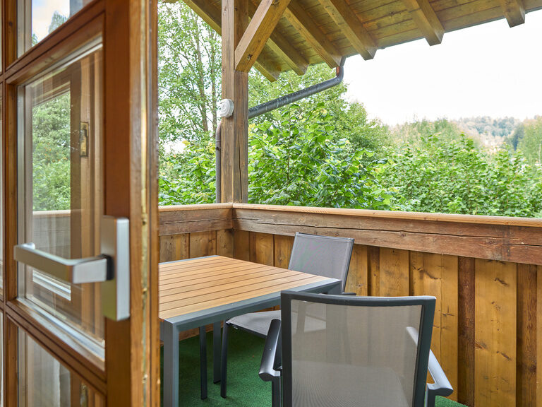 Balkon einer Ferienwohnung im Landhaus Lerchenweg im Bayerischen Wald mit Tisch, Stühlen und Blick ins Grüne