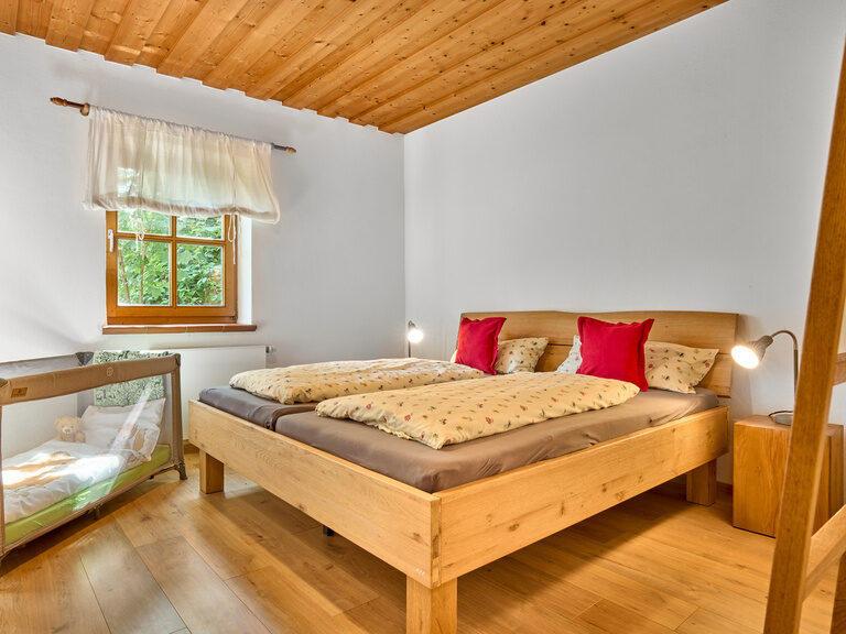 Schlafbereich mit Holzbett und ländlichem Flair im Landhaus Lerchenweg
