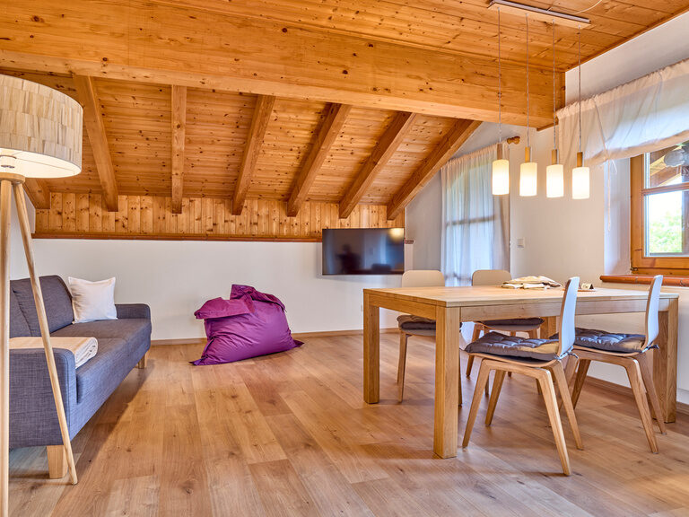 Wohnbereich in der Ferienwohnung im Landhaus Lerchenweg mit Couch und gemütlichem Holzambiente